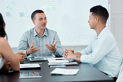 Buy stock photo Shot of a young businessman having a meeting with his colleagues in an office