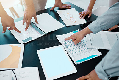 Buy stock photo Closeup shot of a group of unrecognisable businesspeople going through paperwork in an office
