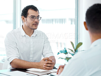 Buy stock photo Shot of a young businessman having a meeting with his colleague in an office