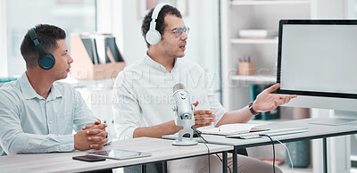 Buy stock photo Shot of two young men using a computer while doing a broadcast in an office