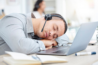 Buy stock photo Shot of a young call centre agent sleeping at his desk in an office