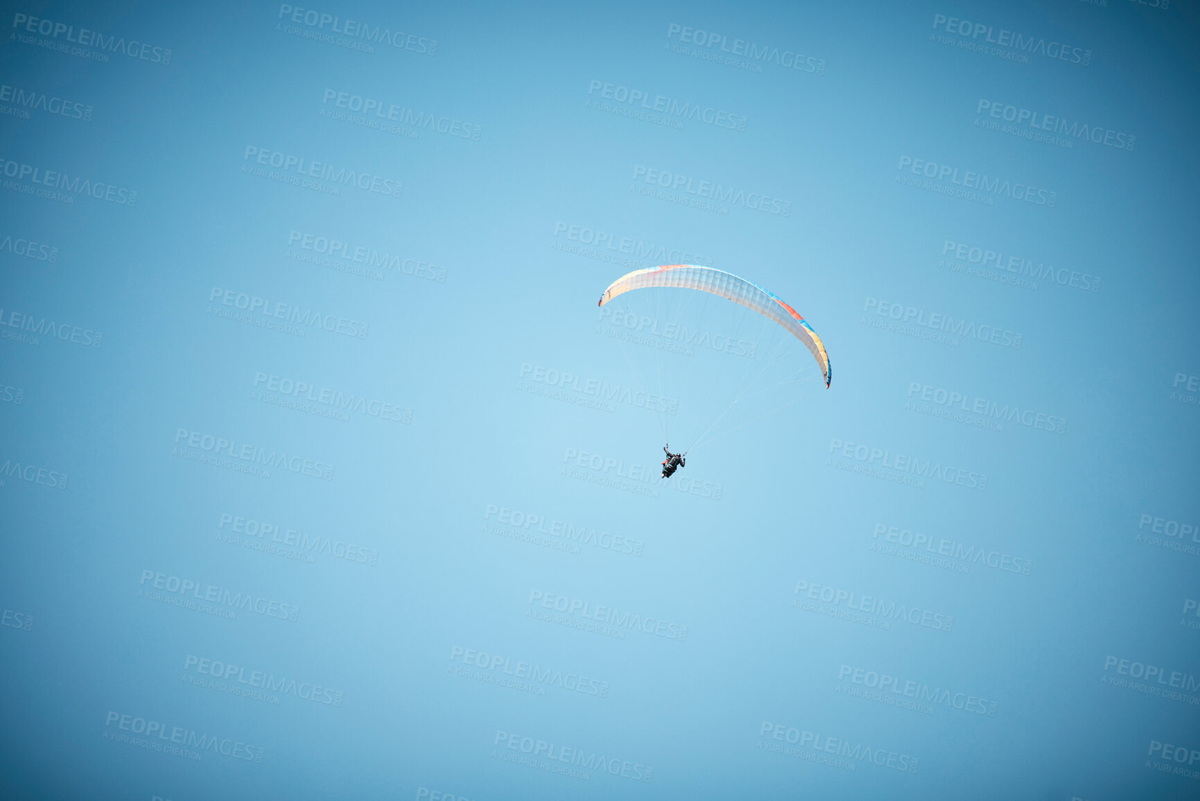 Buy stock photo Shot of a unrecognizable person paragliding in the sky