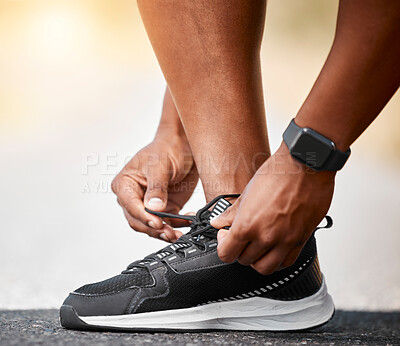 Buy stock photo Shot of a unrecognizable man tying his shoelaces outside