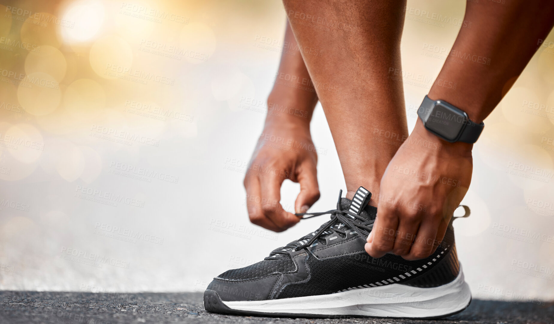 Buy stock photo Shot of a unrecognizable man tying his shoelaces outside