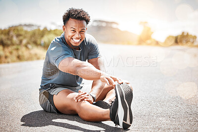Buy stock photo Shot of an athletic young man stretching on a road