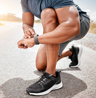 Buy stock photo Cropped shot of an unrecognizable man crouching and checking his watch before going on an outdoor run