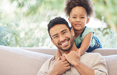 Buy stock photo Cropped portrait of an handsome young man and his adorable little daughter in the living room at home