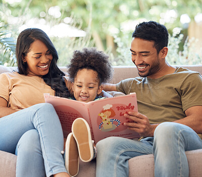 Buy stock photo Cropped shot of an affectionate young family of three reading a book while sitting in the living room at home