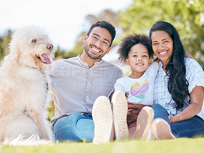 Buy stock photo Shot of a young family sitting outside with their dog