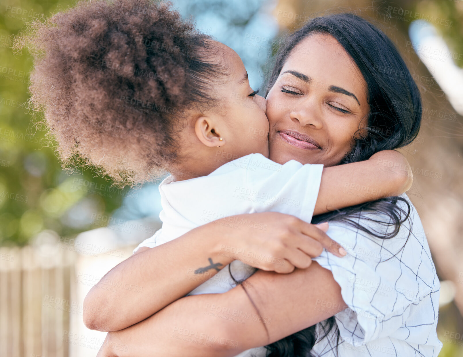 Buy stock photo Mom, daughter and hug with kissing outdoor for mothers day, bonding or affection with smile in nature. Girl, child and mama with embrace or comfort in park for love, care and gratitude for motherhood