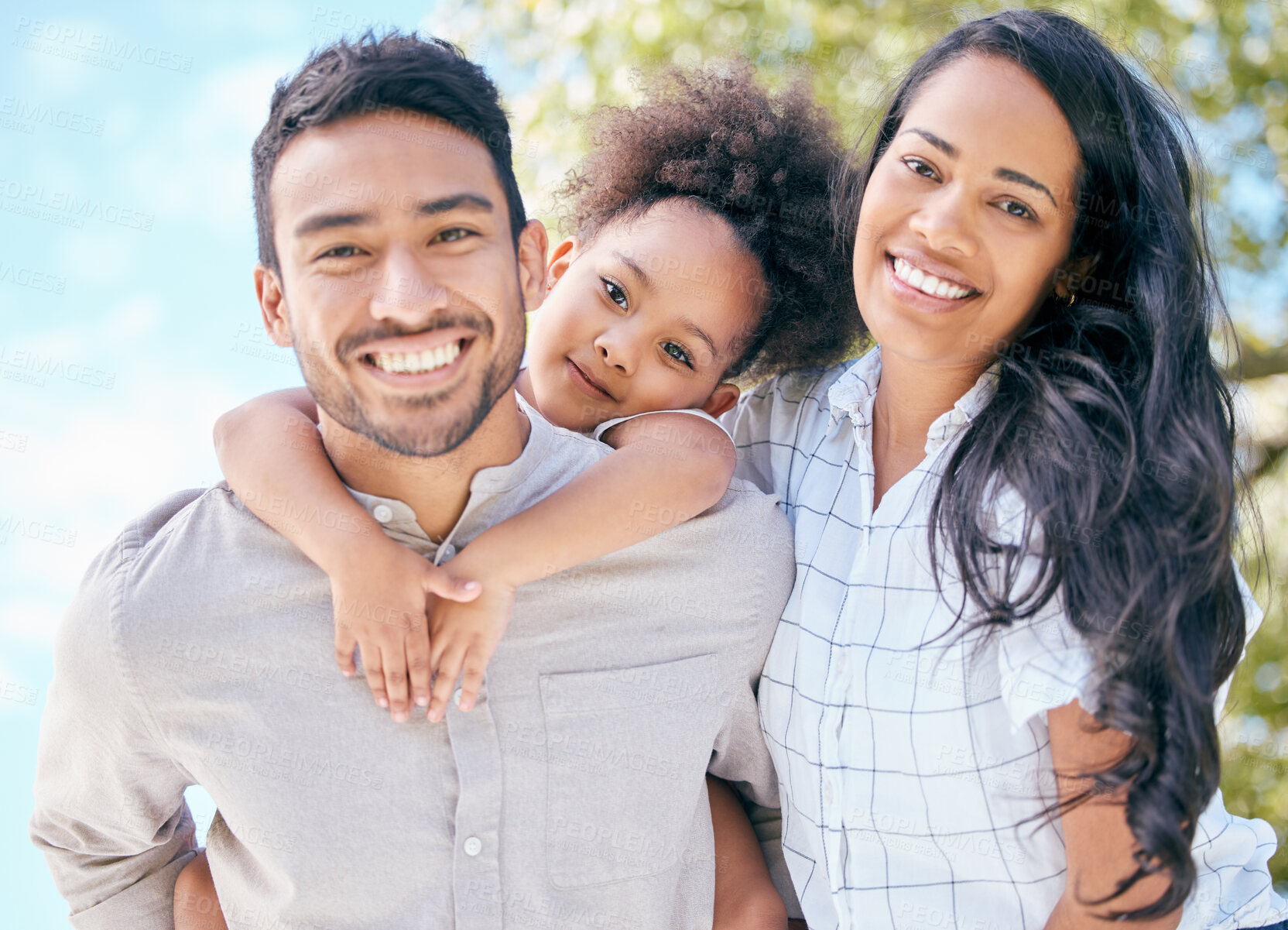 Buy stock photo Shot of a young couple and their adorable daughter spending time together outdoors