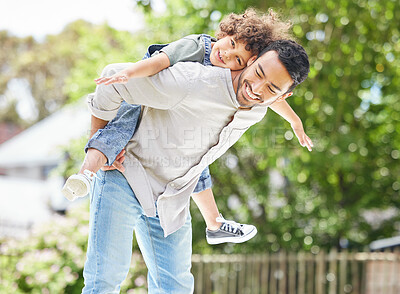 Buy stock photo Shot of a father giving his son a piggyback ride outdoors