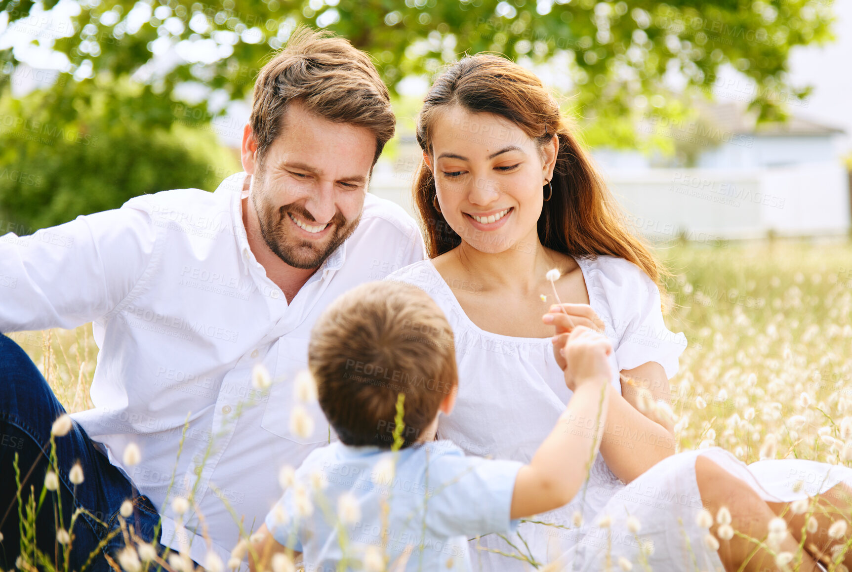 Buy stock photo Family, meadow and flowers to relax together, love and bonding in outdoor plants for talking. Parents, son and happiness in field or security in support, peace and freedom on vacation or countryside