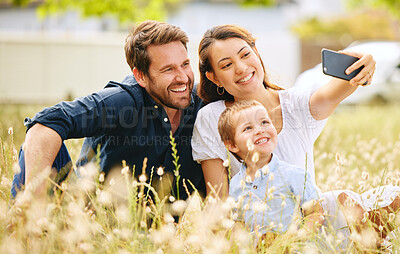 Buy stock photo Shot of a young family taking a selfie while spending time in nature