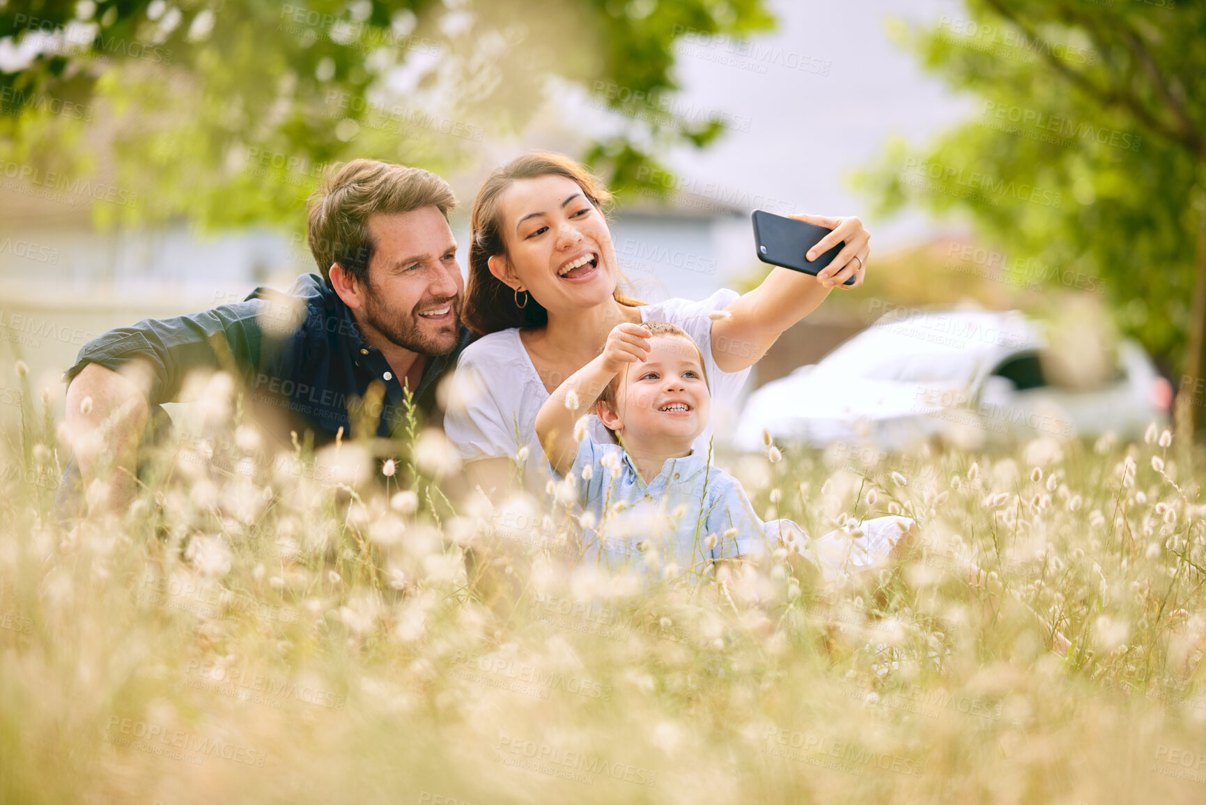 Buy stock photo Family, selfie and nature with flowers, field and trees for bonding, love and social media together outdoor. Woman, kid and man playing at park in summer for happy, memory and post for live streaming