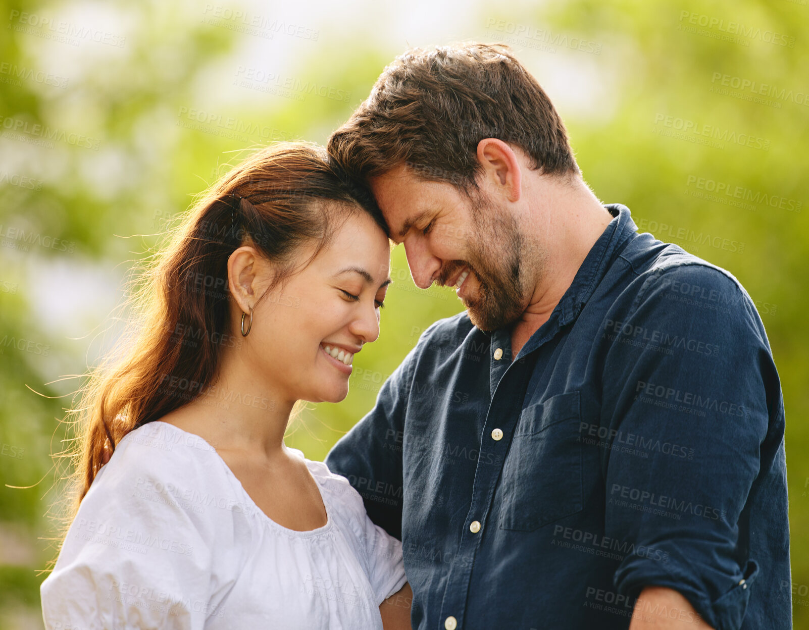 Buy stock photo Couple, forehead touch and date in garden, connection and romance in relationship or affection. People, security and smile for commitment to marriage in outdoor nature, support and weekend in park