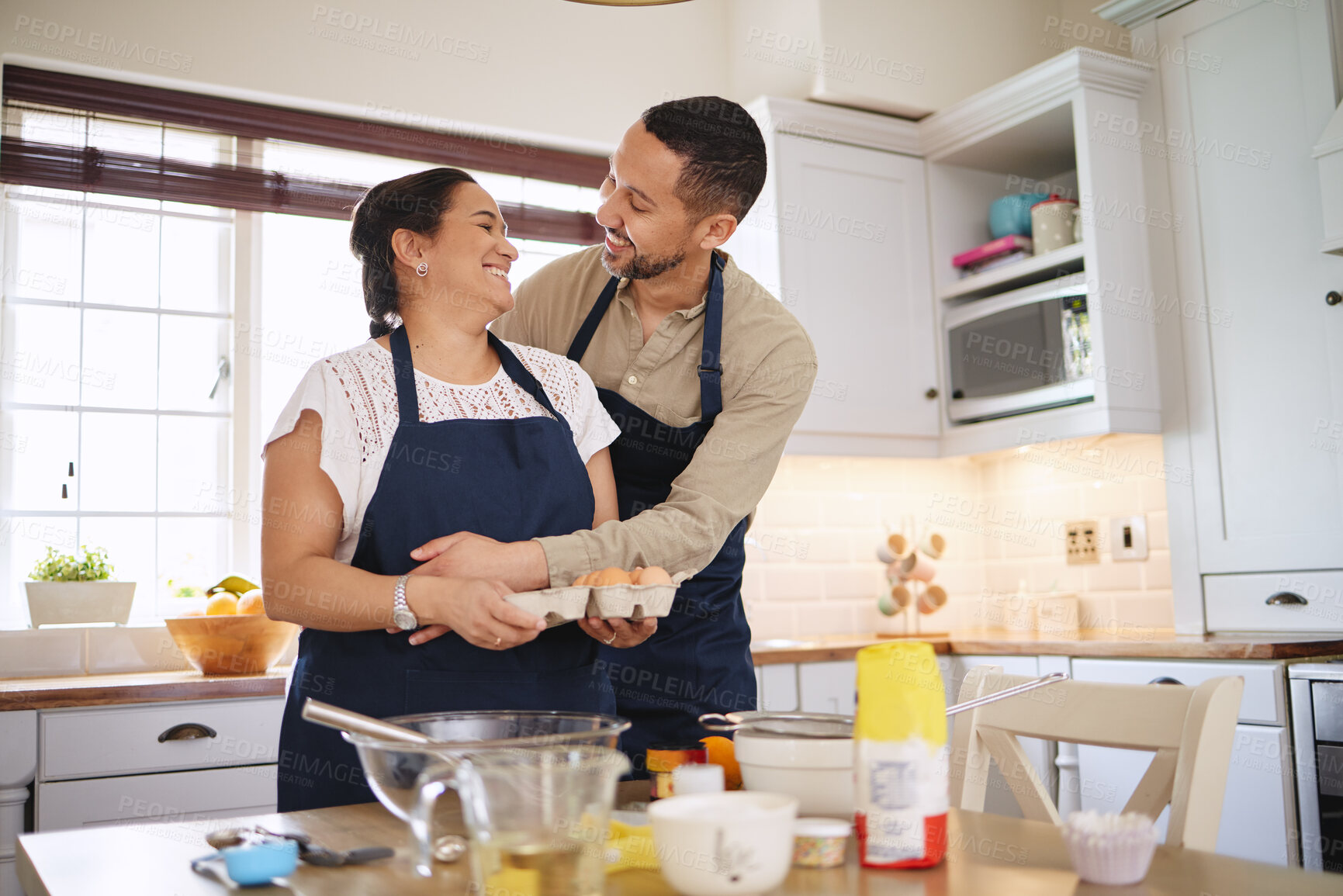 Buy stock photo Couple, hug and baking in kitchen with food for healthy relationship and ingredients for cake in home. Happy marriage, man and woman with cooking or making biscuits together for breakfast and bonding