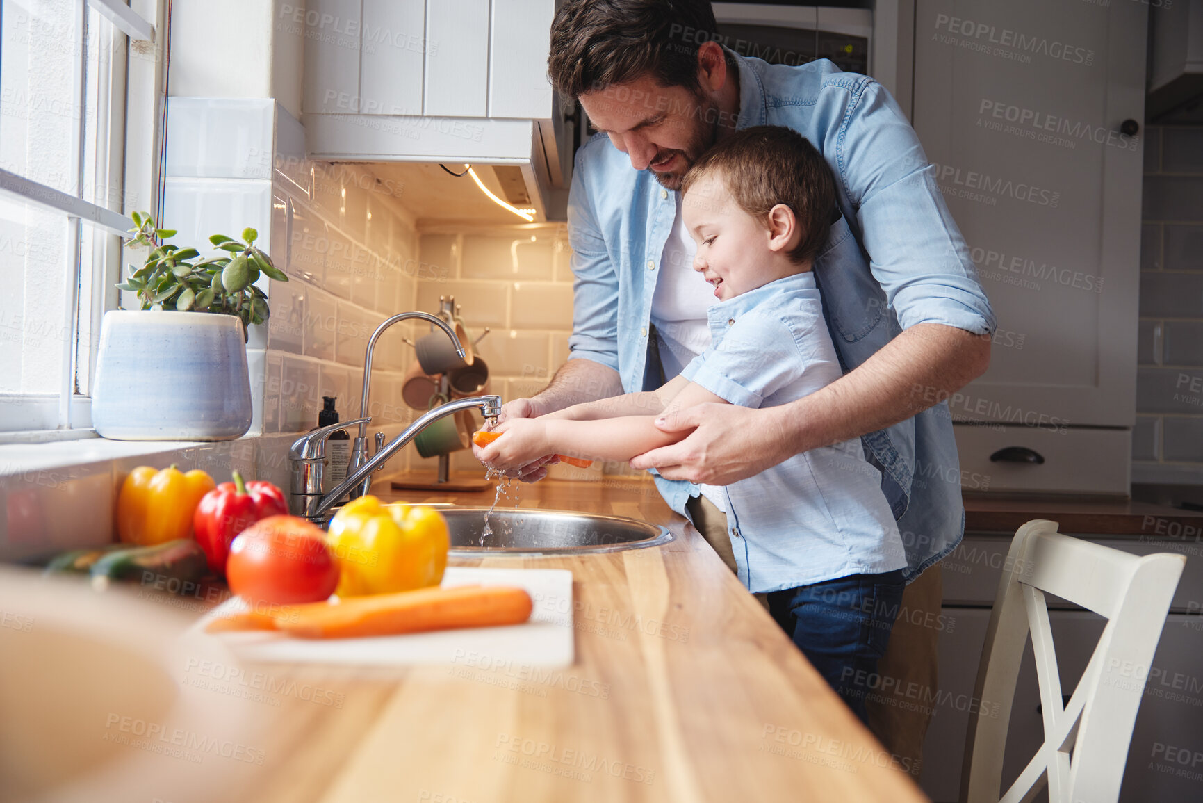 Buy stock photo Kid, father and washing vegetables for cooking organic food, nutrition or learning healthy diet. Dad, happy child or cleaning carrot in kitchen for hygiene, wellness or teaching boy meal prep in home