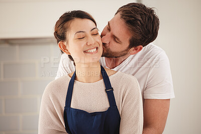 Buy stock photo Shot of a man kissing his wife on her cheek at home