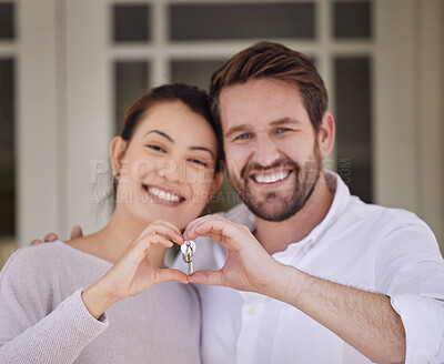 Buy stock photo Shot of a young couple forming a heart shape with their hands while standing outside