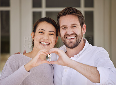 Buy stock photo Shot of a young couple forming a heart shape with their hands while standing outside