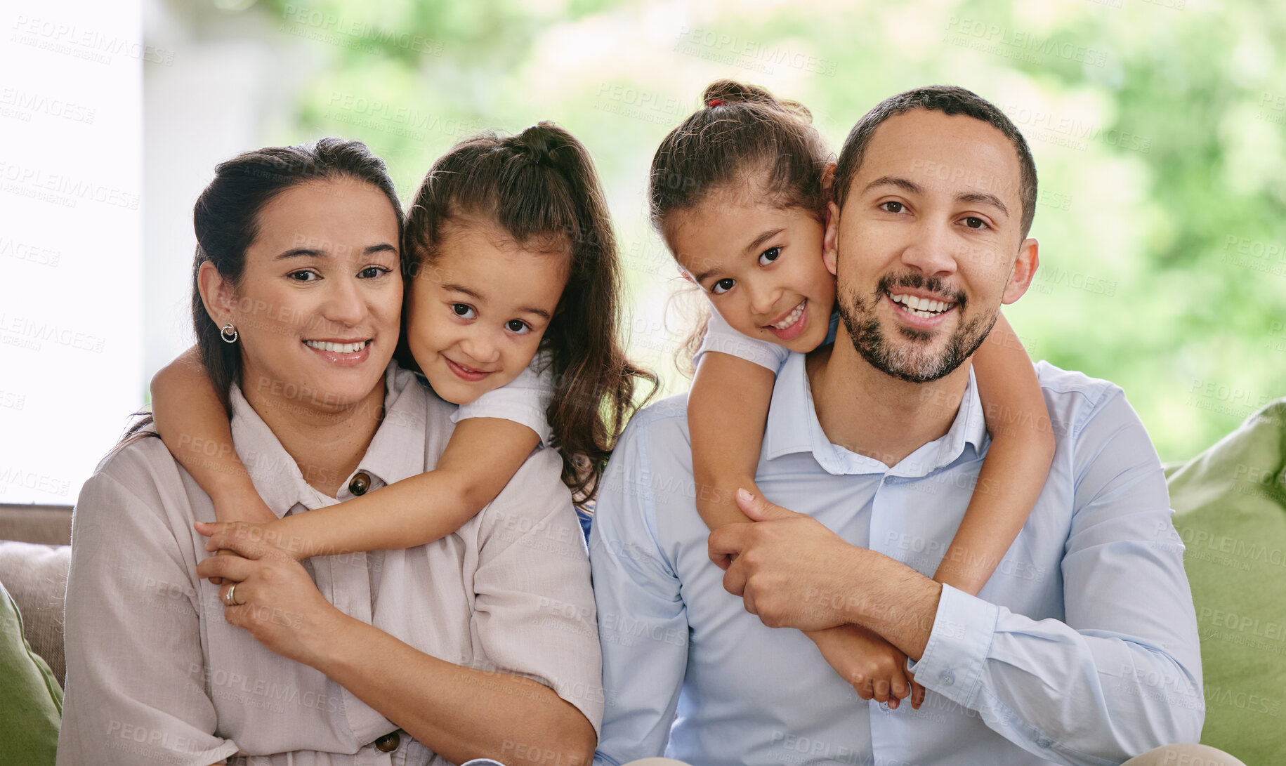 Buy stock photo Love, hug and portrait of happy family on a sofa, embrace and piggyback in their home together. Face, smile and children hugging parents in a living room, sweet and cute, bonding and enjoying weekend