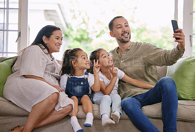 Buy stock photo Family, smile and selfie on sofa at house for love, bonding and care for photography of social media post. Happy, woman and man with girls in living room, picture and peace sign for childhood memory