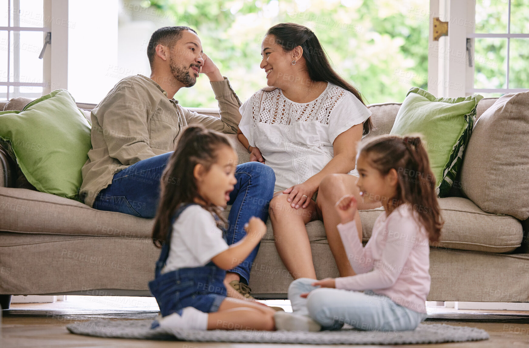 Buy stock photo Parents, kids and together in living room for games, conversation and relaxation on sofa at home. Sisters, mother and father on couch for weekend, development and playful on floor in family home