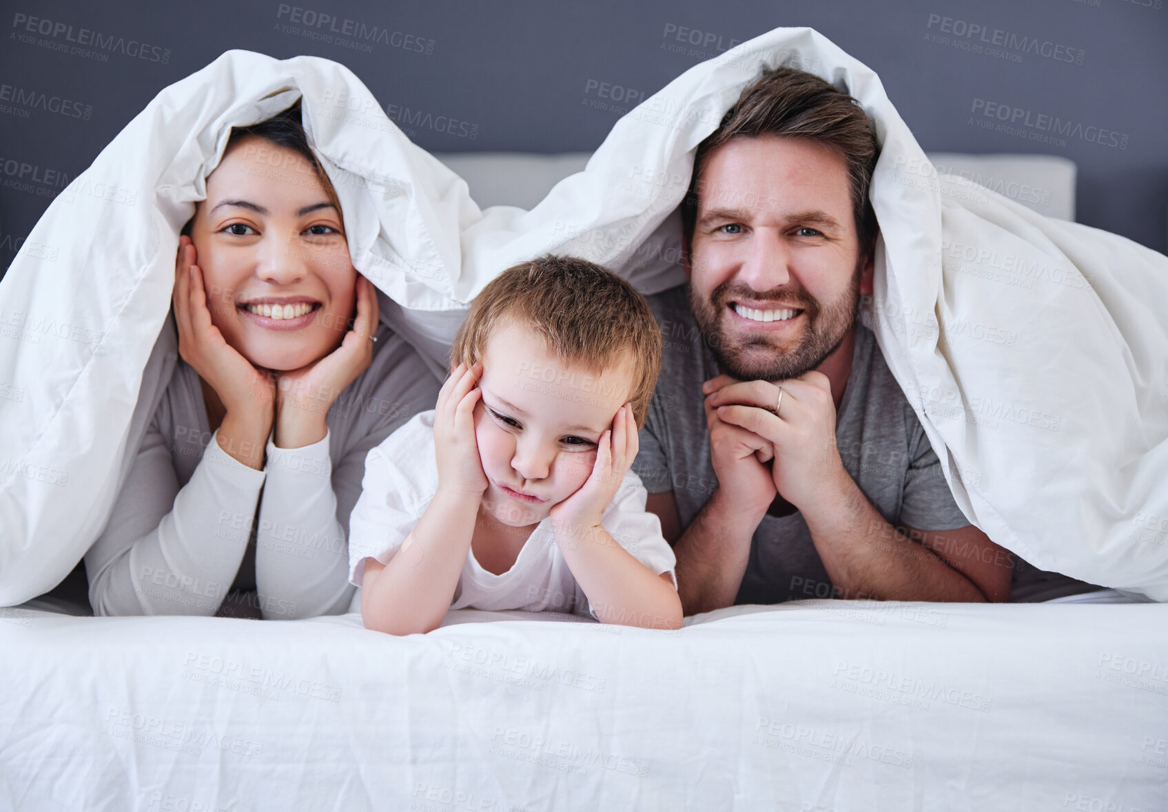 Buy stock photo Mother, son and father in bedroom, portrait and bonding with love, man and woman with care for boy in home. Mom, dad and kid together on bed, happiness and relax in weekend, parents or child in house