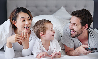 Buy stock photo Shot of a young family watching tv together at home