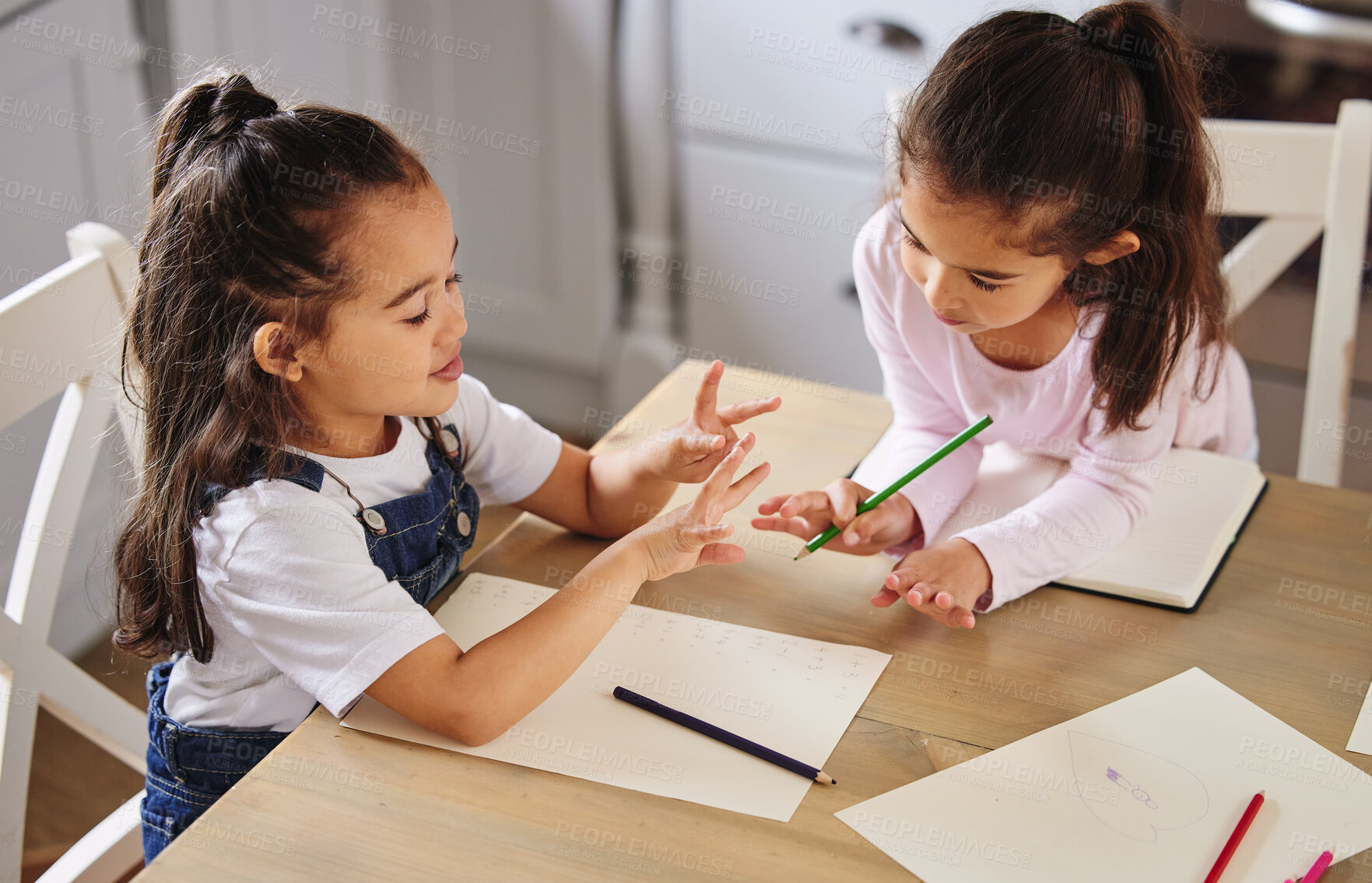 Buy stock photo Girl, children and together for education, homework and  development by studying and learning at home. Support, students and pencil as sisters for teamwork, growth or help with books or sketch