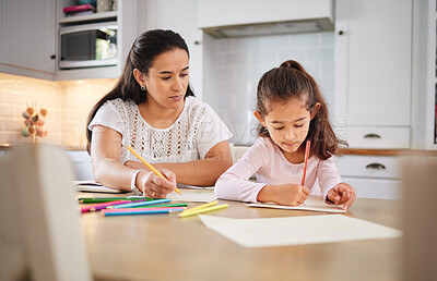 Buy stock photo Shot of a young woman helping her daughter with her homework