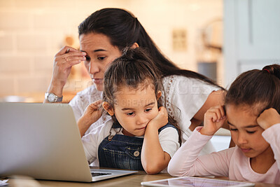 Buy stock photo Shot of a young mother helping her daughters with their homework