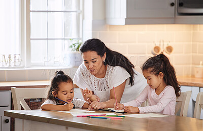 Buy stock photo Shot of a young woman helping her daughters with their homework