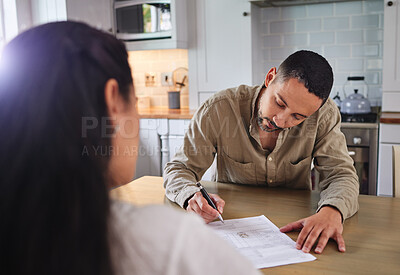 Buy stock photo Shot of a young couple signing divorce papers