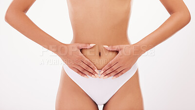 Buy stock photo Shot of a female holding her stomach against  a grey  background