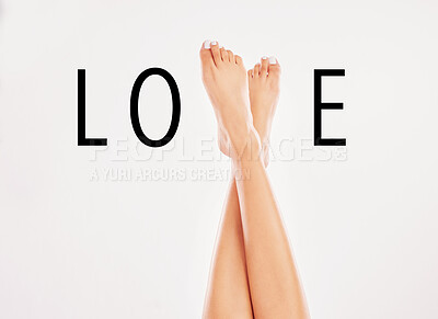 Buy stock photo Closeup, legs and woman with love, sign and text with beauty on grey studio background. Feet, person and model with letters, wellness or skincare for pedicure promotion, grooming routine or treatment