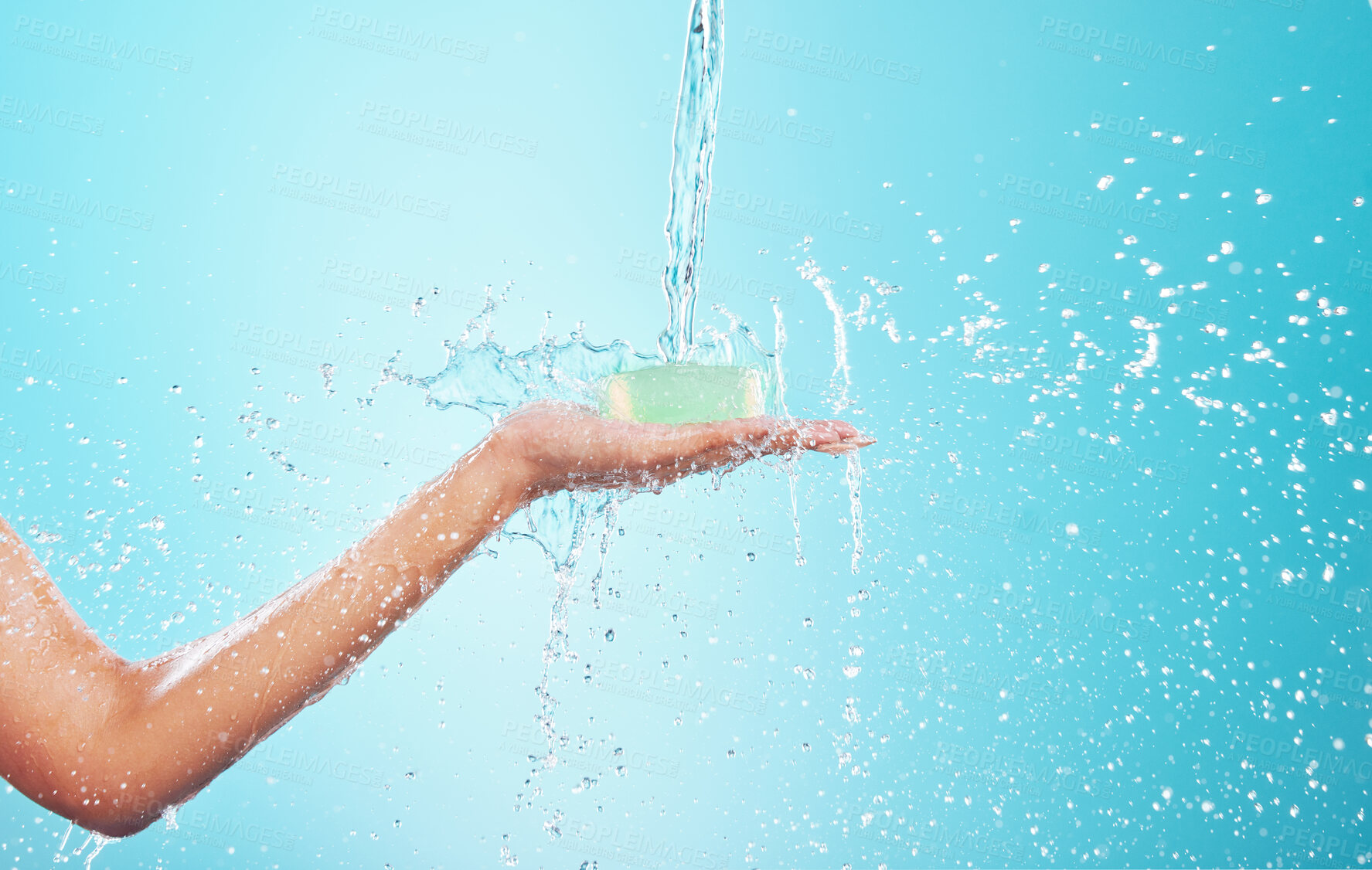 Buy stock photo Water, washing and person hands with soap, cleaning and hygiene in studio for wellness. Health, care and morning routine with palm, protection and safety from germs with blue background and splash