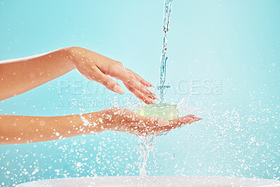 Buy stock photo Water, cleaning and person hands with soap, washing and hygiene in studio for wellness. Health, care and morning routine with splash, protection and safety from germs with blue background in bathroom