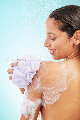 Buy stock photo Shot of an young woman enjoying a soapy shower against a blue background