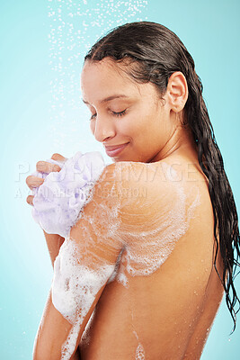 Buy stock photo Shot of an young woman enjoying a soapy shower against a blue background