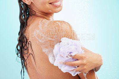 Buy stock photo Shot of an young woman enjoying a soapy shower against a blue background