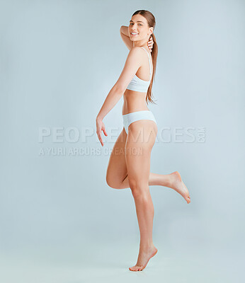 Buy stock photo Shot of a beautiful young woman wearing underwear while posing against a grey background