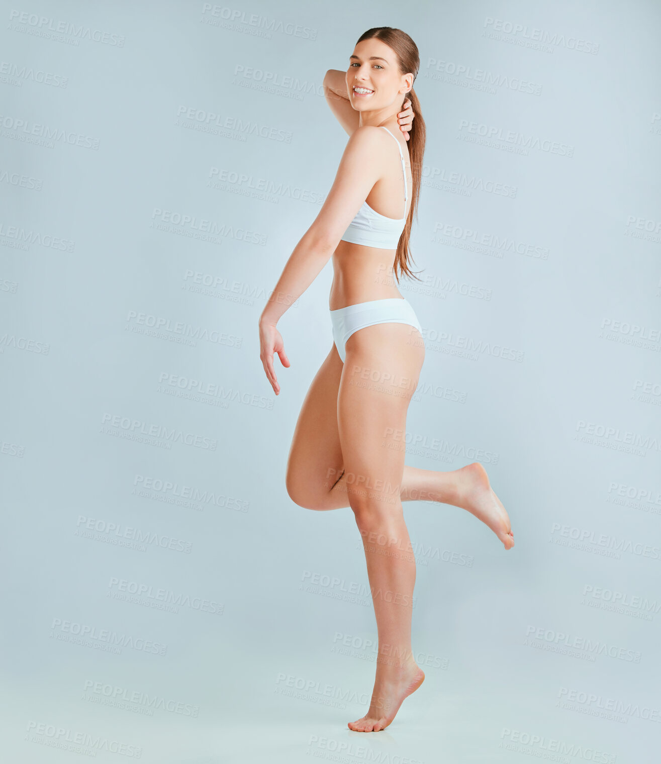 Buy stock photo Shot of a beautiful young woman wearing underwear while posing against a grey background