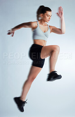 Buy stock photo Woman, fitness and runner with jump of athlete in speed for sports, training or agility on a gray studio background. Active female person with motion blur in air for running, endurance or athletics