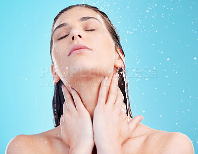 Buy stock photo Shot of a beautiful young woman being splashed with water against a blue background