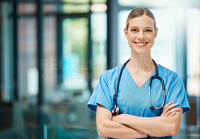 Buy stock photo Shot of a young female doctor standing with her arms crossed at a hospital