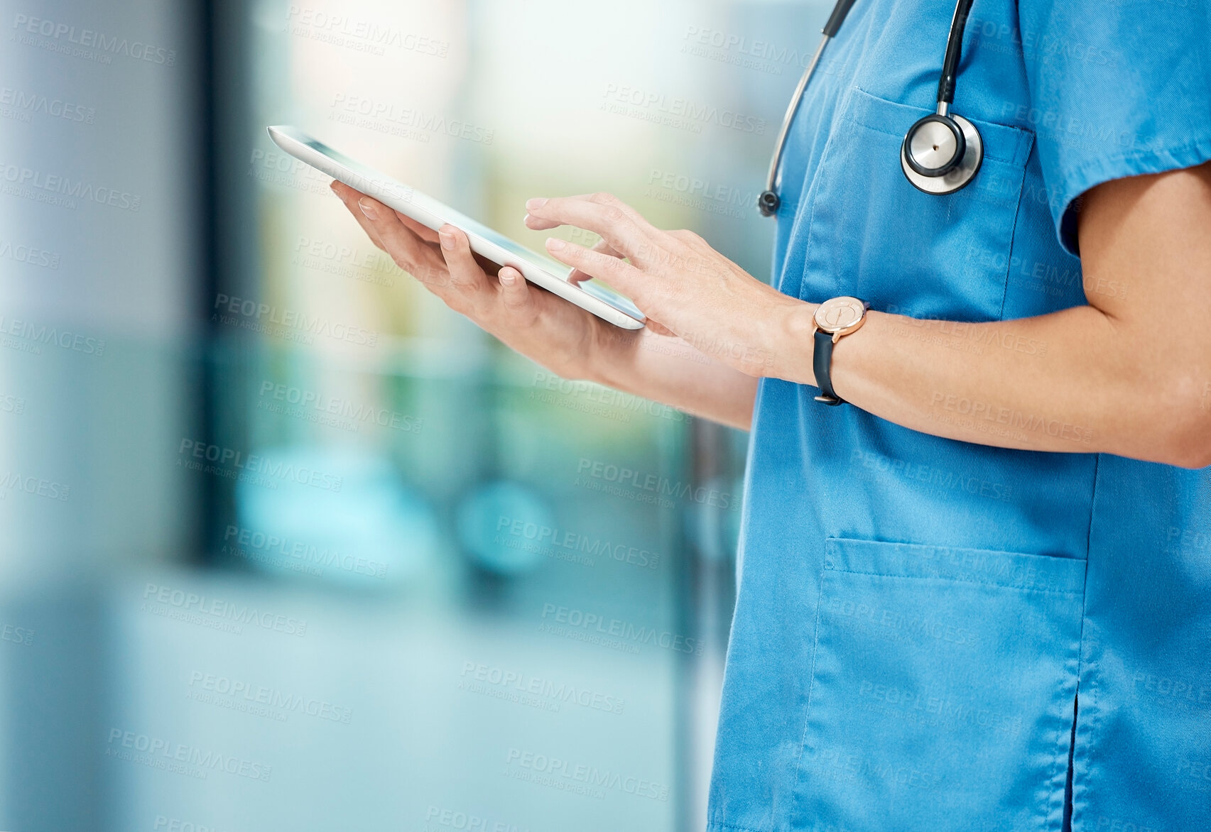 Buy stock photo Shot of an unrecognizable doctor using a digital tablet at a hospital