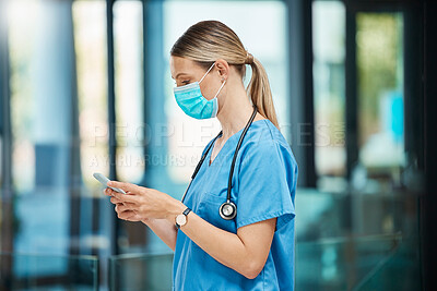 Buy stock photo Shot of a young female doctor using a phone at a hospital