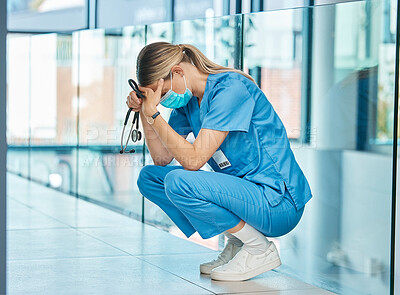 Buy stock photo Shot of a young female doctor looking tired while working in a modern hospital